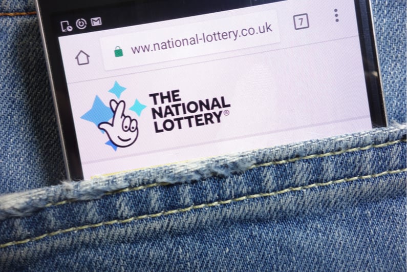 The National Lottery logo on phone screen in pocket