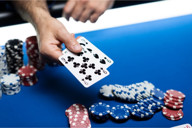 Man showing two black nines in a poker game