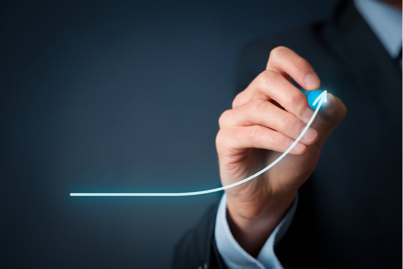 Businessman drawing an upward-sloping curve