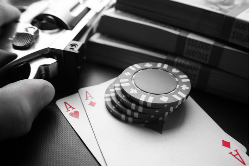 Playing cards, poker chips, and a gun