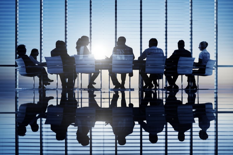 Silhouettes of business people around a conference table