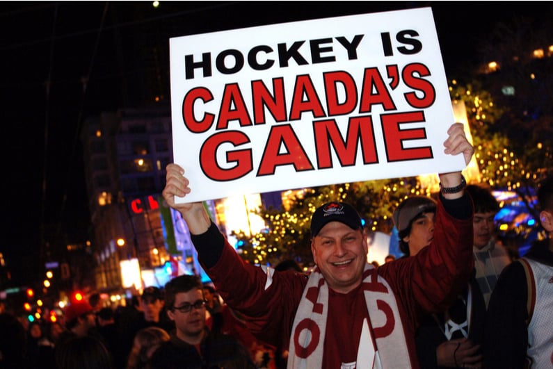 Man holding up a sign reading "Hockey is Canada's Game"