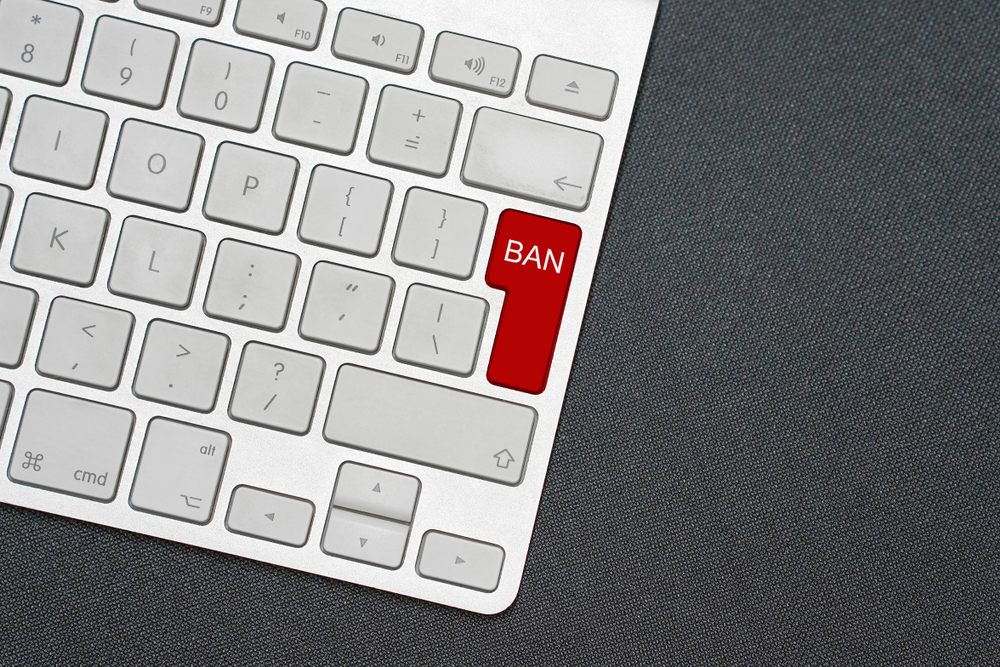 Red Enter button on computer keyboard reads "Ban"