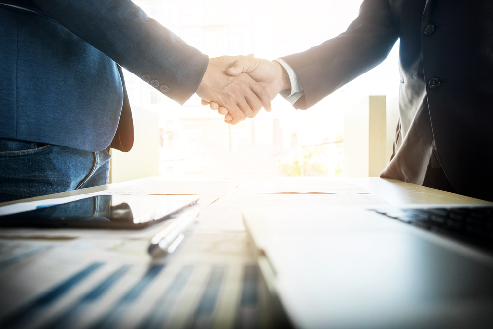 two businesspeople shaking hands as a gesture of agreement