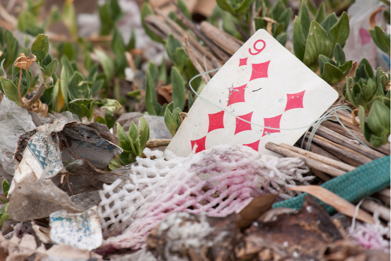 Old playing card in a pile of garbage