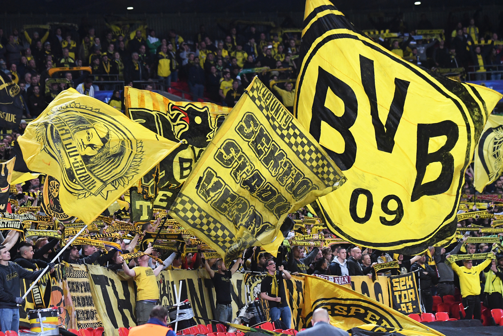 Borussia Dortmund fans waving club flags in soccer stadium