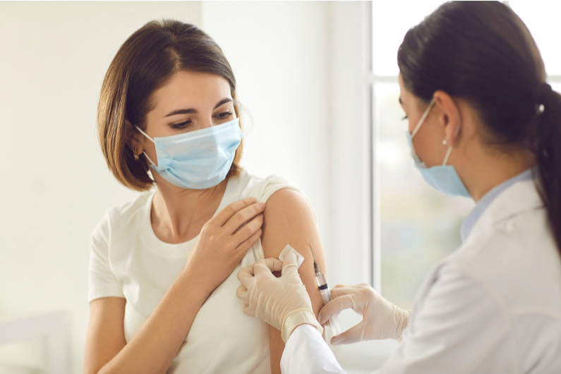 nurse administering vaccine to woman