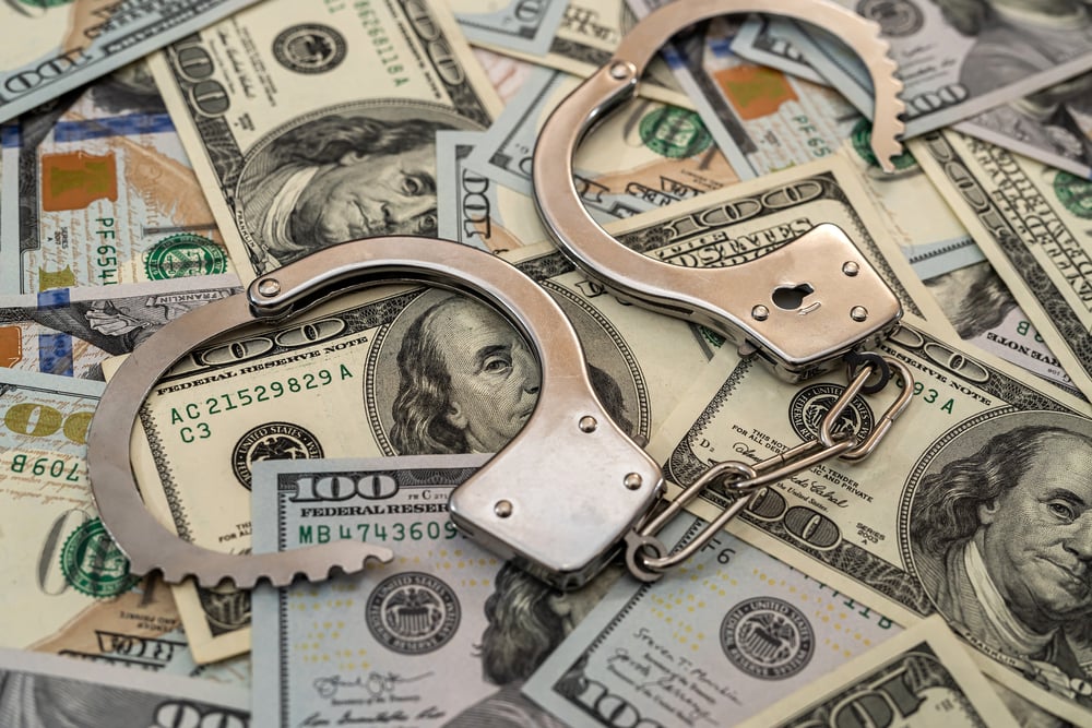 handcuffs on US dollar bills