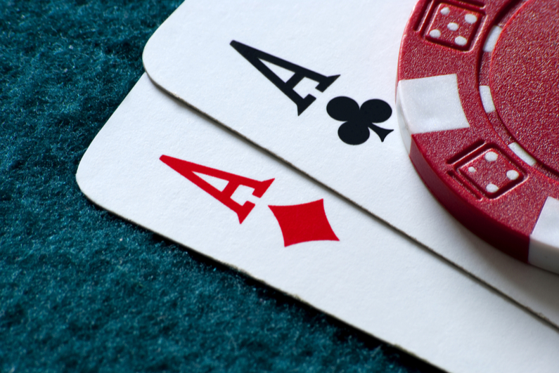 Two Aces and a poker chip on blue felt