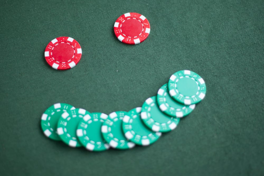 poker chips on green felt in the shape of a smiling face