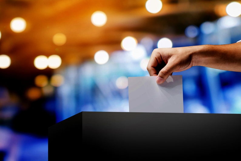 Hand dropping ballot into box