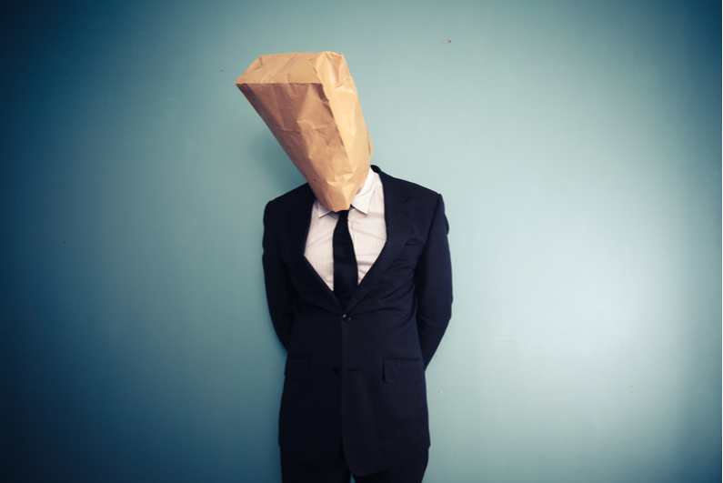 Man in a suit with a bag over his head