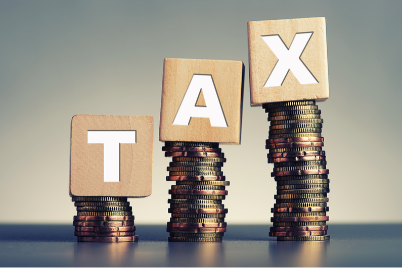 Blocks spelling out "TAX" on stacks of coins