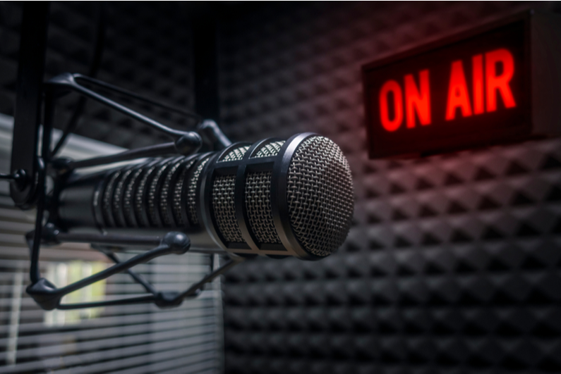 Professional mic in a broadcast studio with an "ON AIR" sign in the background