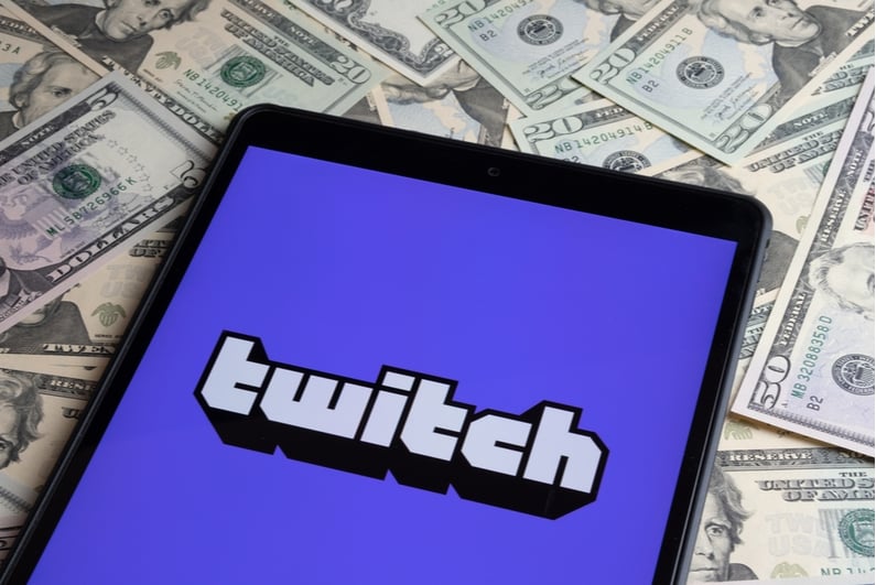 Twitch logo on an iPad sitting on top of cash