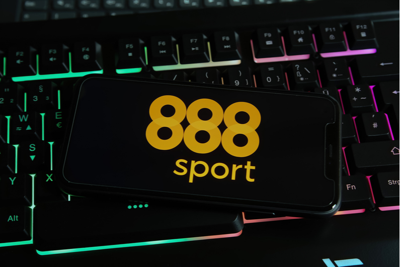 smartphone showing 888sport logo sitting on an RGB-lit keyboard
