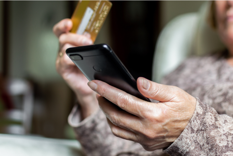 Elderly woman shopping online with a credit card