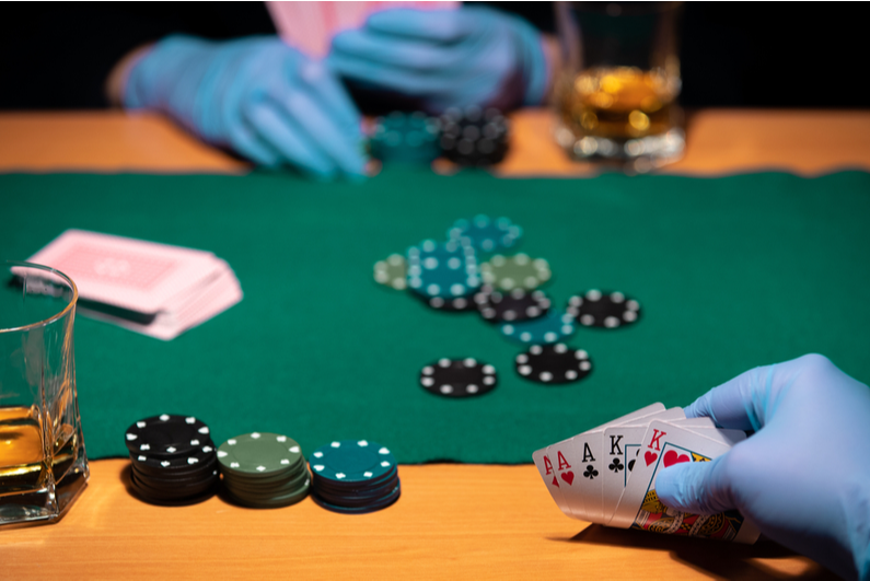 Poker players wearing surgical gloves