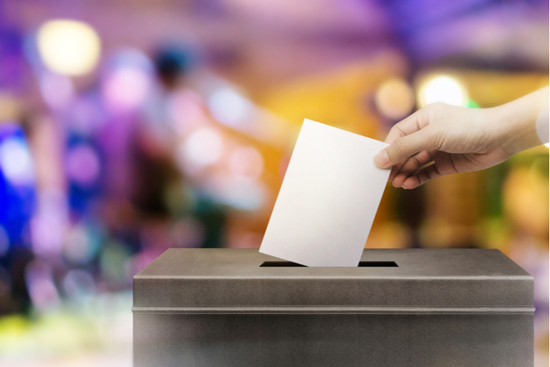 Person placing a vote in a box
