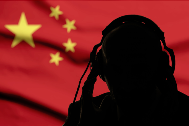 Silhouette of person listening to headphones with Chinese flag in the background