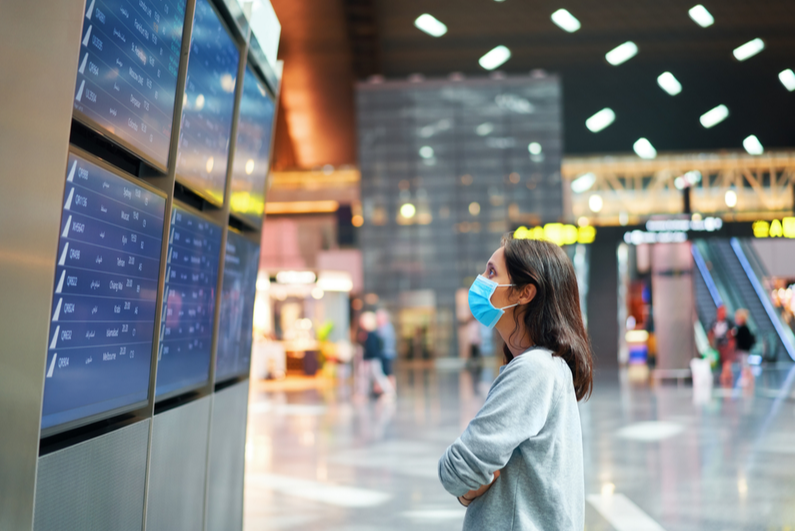 Woman looking at flights board in airport