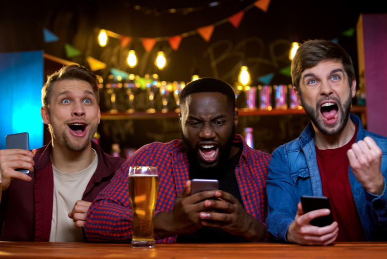 Three men celebrating in a bar