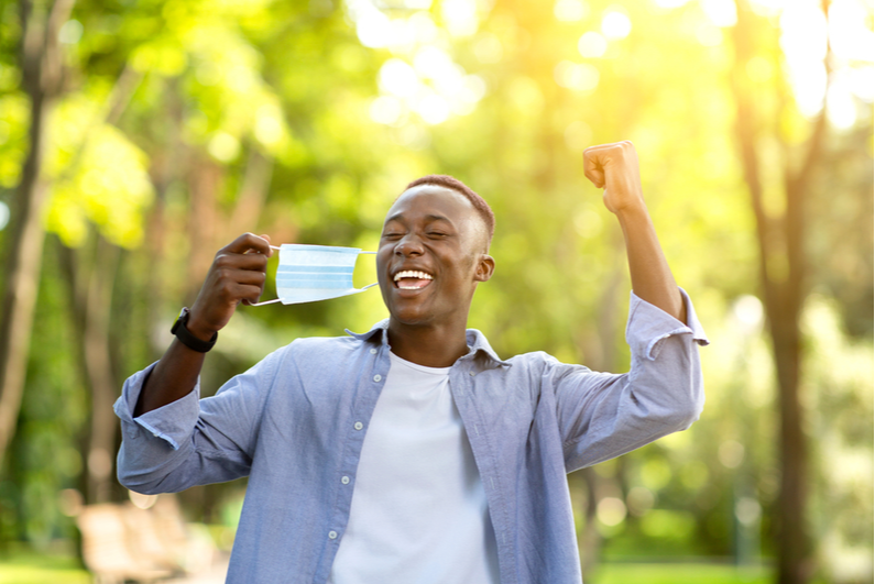 Man celebrating taking off a mask