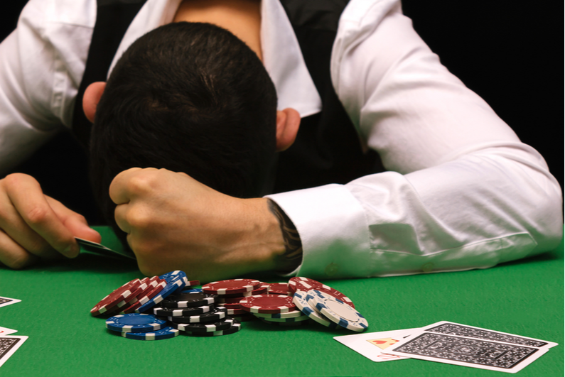 Person with head on poker table