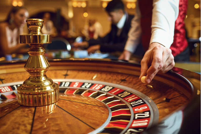 Croupier putting a ball into the roulette wheel