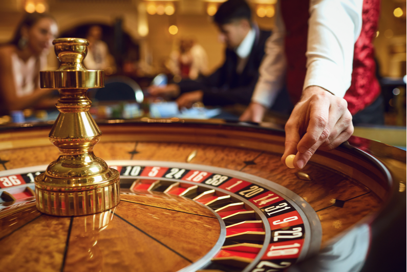 The dealer puts a ball in the roulette wheel