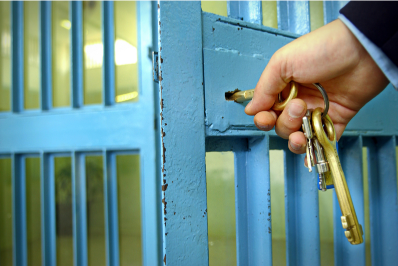 Prison guard locking a cell