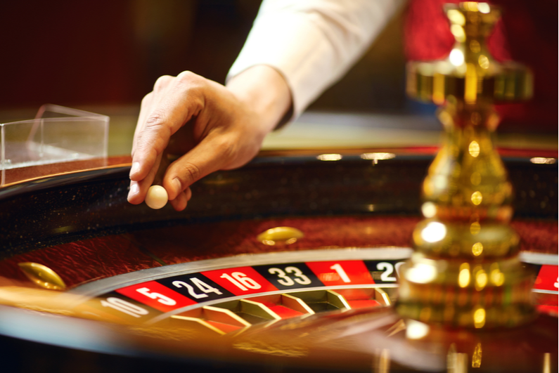 Croupier placing the ball on a roulette wheel