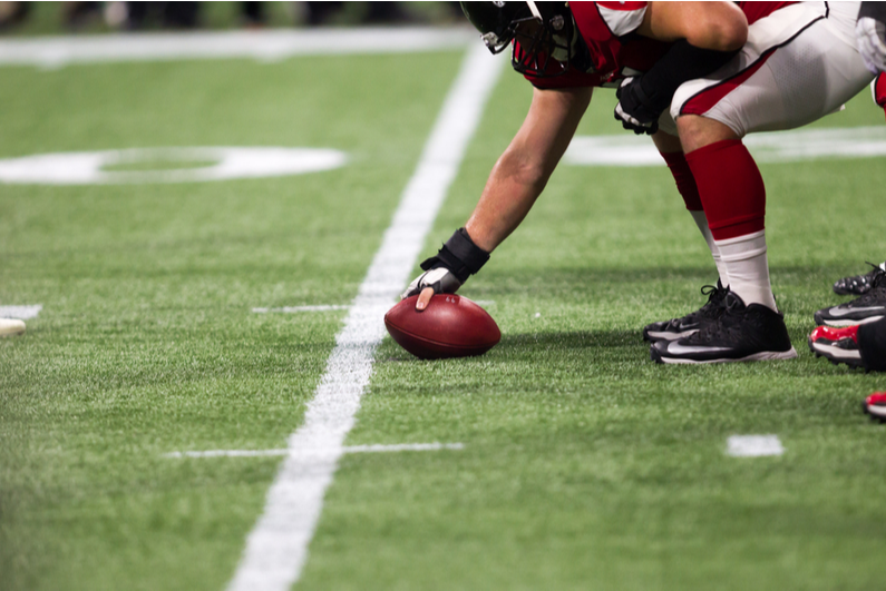Closeup of the ball about to be snapped at an Atlanta Falcons game
