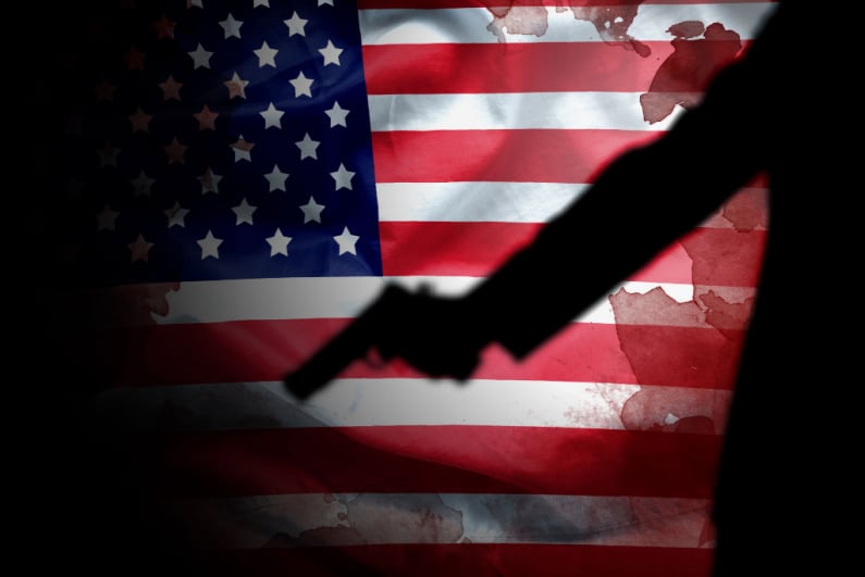 Schatten eines Mannes mit Waffe über der US-Flagge