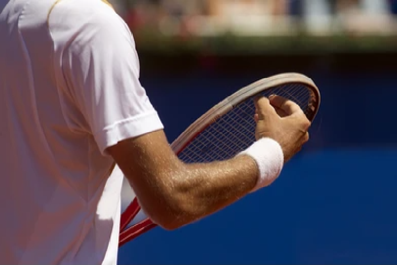 Tennis player checking the strings of the racket