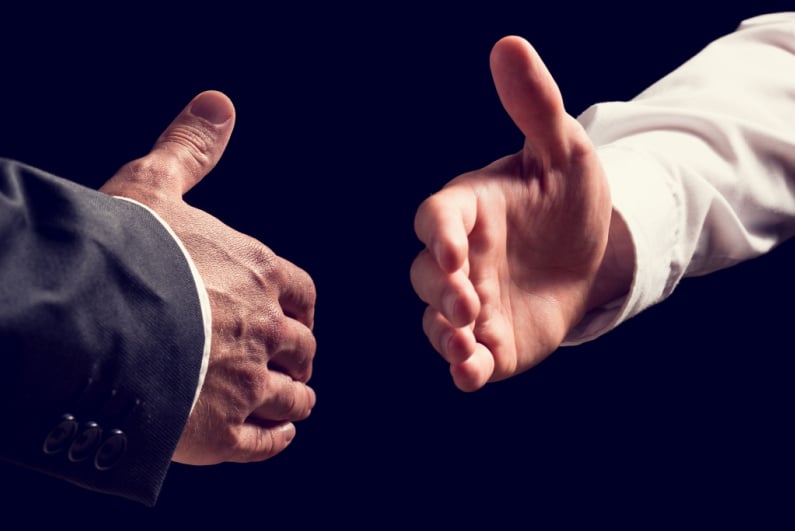 Two businessmen about to shake hands