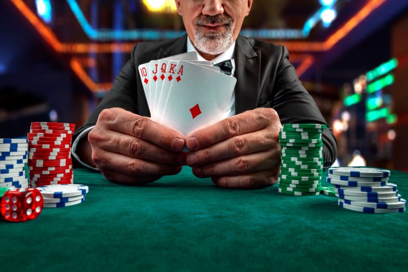 Older poker player showing a royal flush