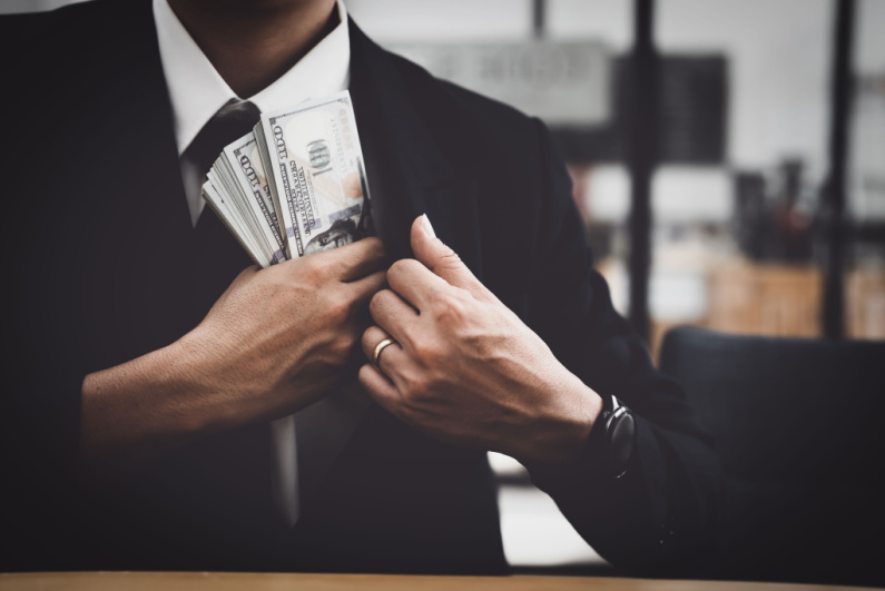 Man pocketing stacks of cash