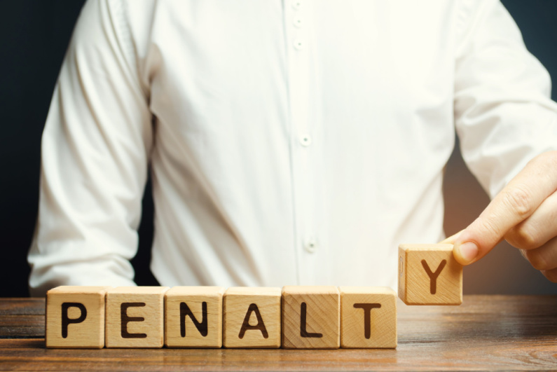 Man arranging blocks to spell "PENALTY"