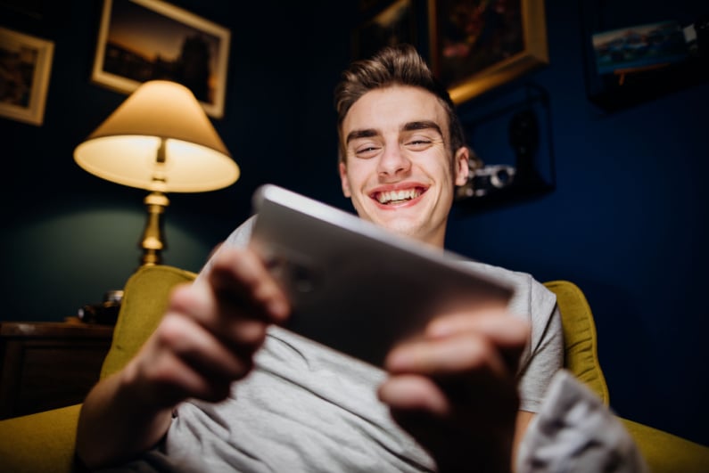 Young man smiling at phone