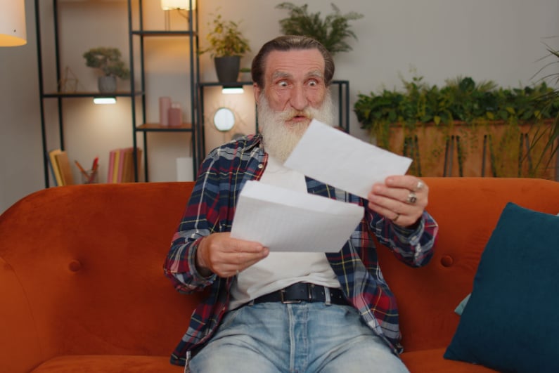 Elderly man opening letter