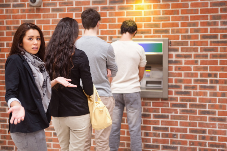 Frustrated woman waiting at ATM