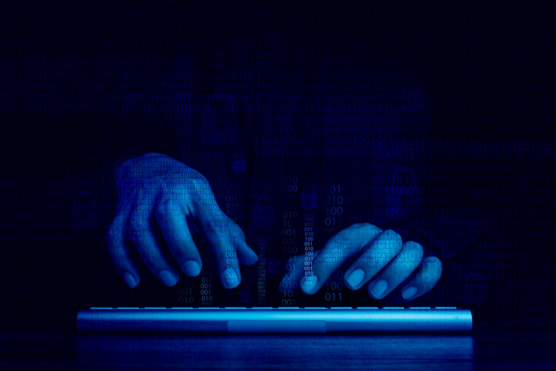 Shadowy hands typing on a keyboard