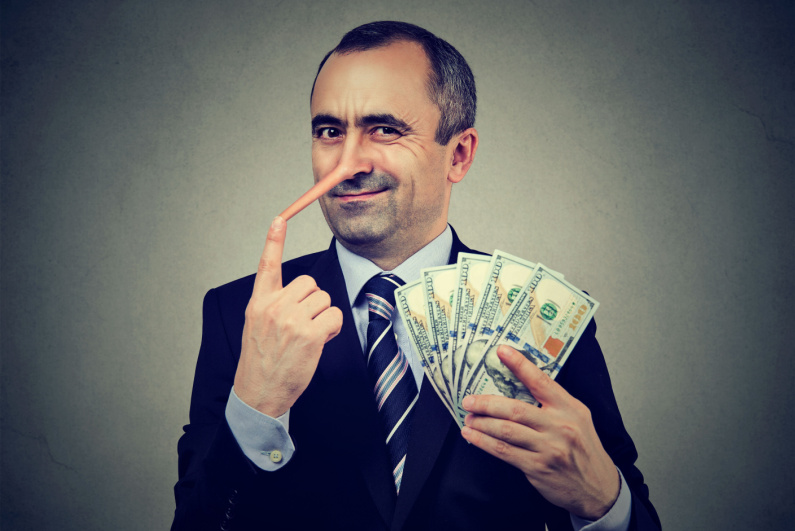 Man holding cash and pointing to his Pinnochio-like nose