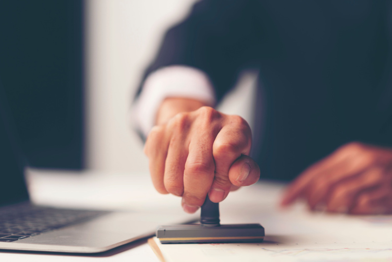 Man stamping approval on a document