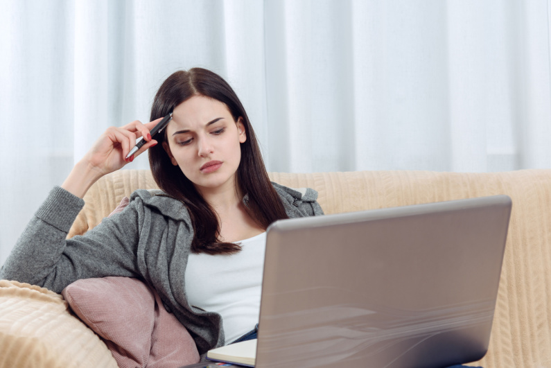 Woman looking pensively at her laptop
