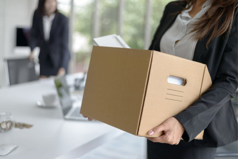 Business woman carrying box of things out of office