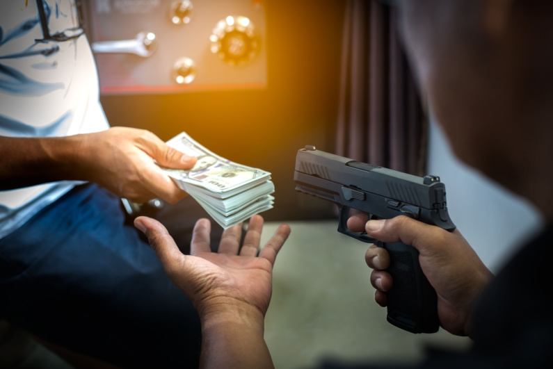 Man with a gun robbing cash