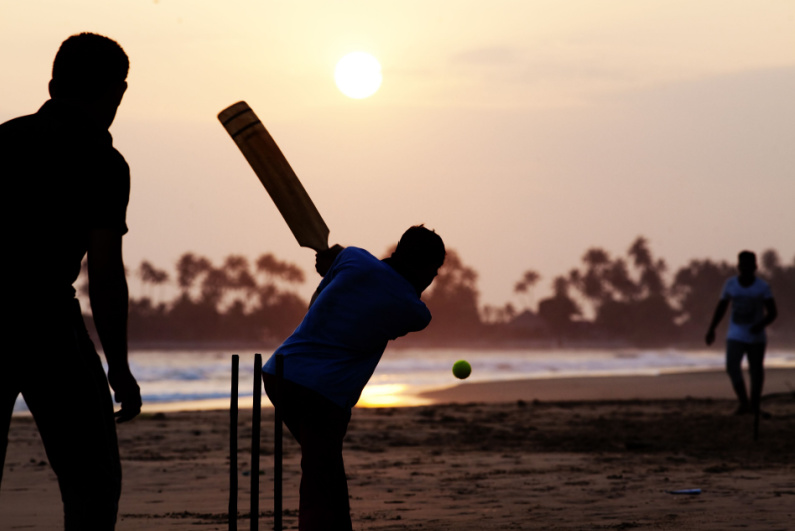 People playing cricket on a beach in Sri Lanka