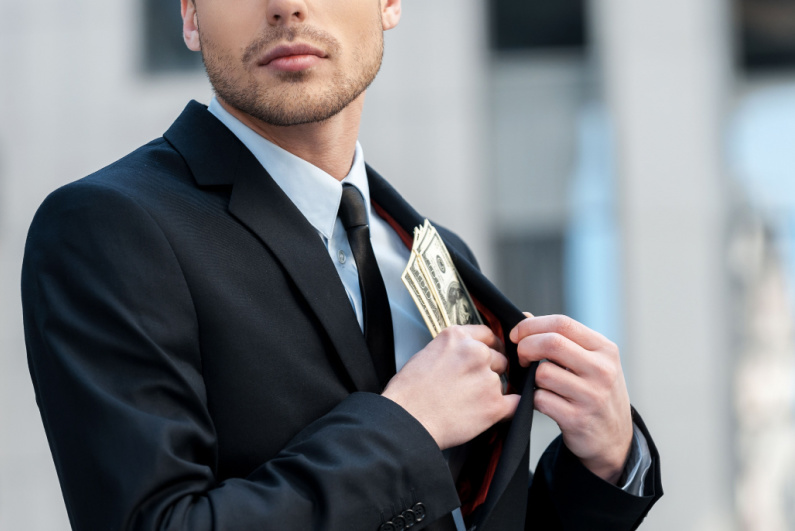 Man putting money in jacket